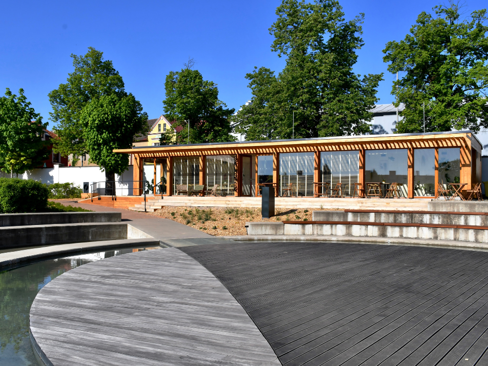 Architektonické provedení bistra Skleník v parku před fontánou.