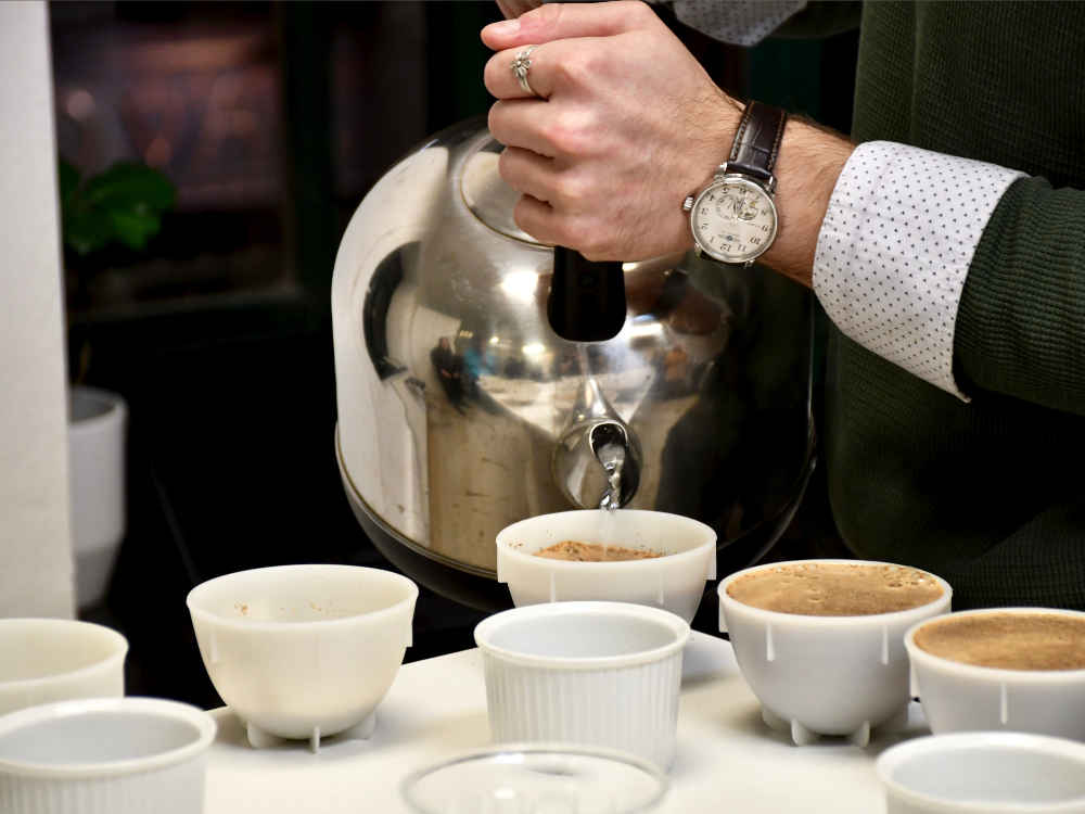 Zalévání kávy v připravených cuppingových miskách.