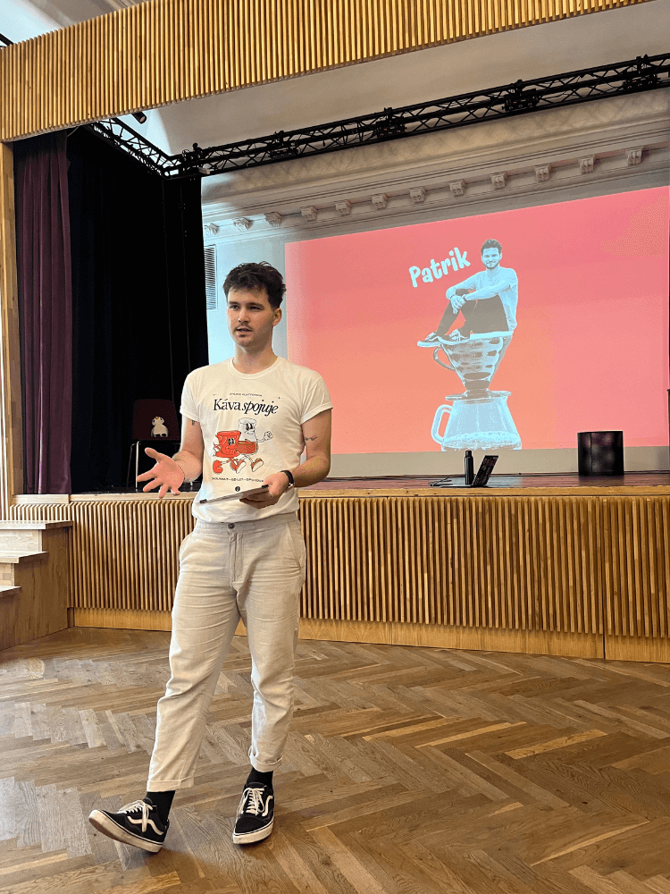 Patrik přednáší ve velkém sále kavárny Pikola Sedmička.