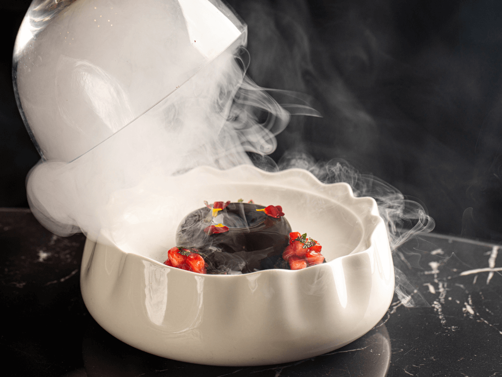 Čokoládový dezert v míse naplněné kouřem, která se nadzvedla.
