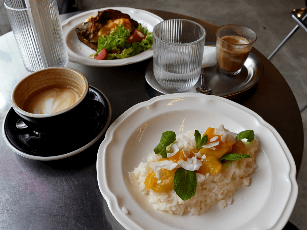 Stůl s rýžovou kaší a toastem v pozadí.